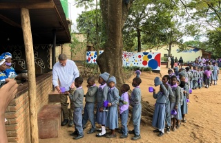 Magnus MacFarlane-Barrow serviert Kindern in Malawi Essen.