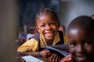 Ein Mädchen lacht im Unterricht in Liberia.