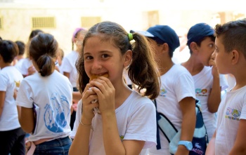 Ein junges Mädchen genießt Essen in ihrer Schule in Syrien.