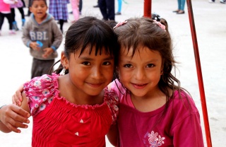 Zwei Mädchen posieren zusammen auf einem Spielplatz in Ecuador.