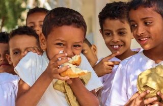 Ein junger Junge genießt Essen in seiner Schule im Jemen.