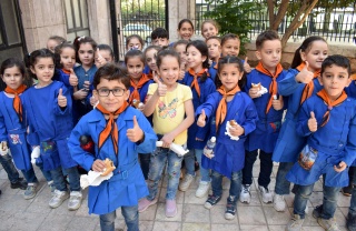 Kinder in Syrien zeigen Daumen hoch, während sie Essen von unserem Partner, Dorcas, erhalten.