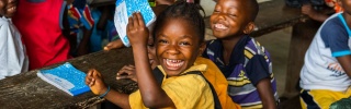 Ein junges Mädchen freut sich in einem Klassenzimmer in Liberia.