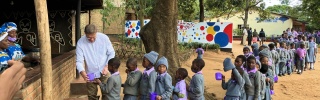 Magnus MacFarlane-Barrow serviert Kindern in Malawi Essen.