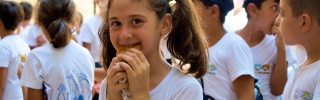 Ein junges Mädchen genießt Essen in ihrer Schule in Syrien.