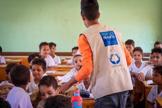 Ein Freiwilliger spricht mit Kindern im Unterricht.