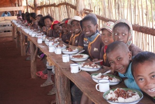 Kinder in der Klasse sitzen zusammen, um gemeinsam Essen in der Klasse zu essen.