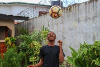 Ein Junge spielt mit einem Fußball.