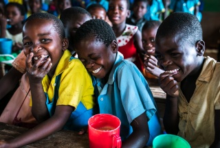 Junge Jungen teilen sich während des Unterrichts in Malawi einen Witz.