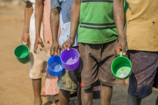 Kinder in Malawi stellen sich für Essen in einer Schlange an.